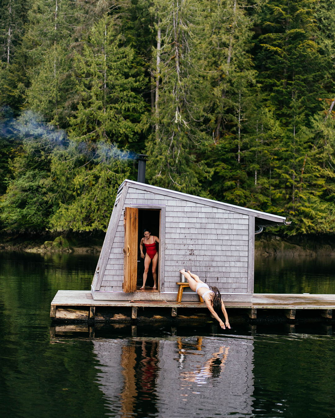 Two girls in Left On Friday swimsuits on a floating sauna