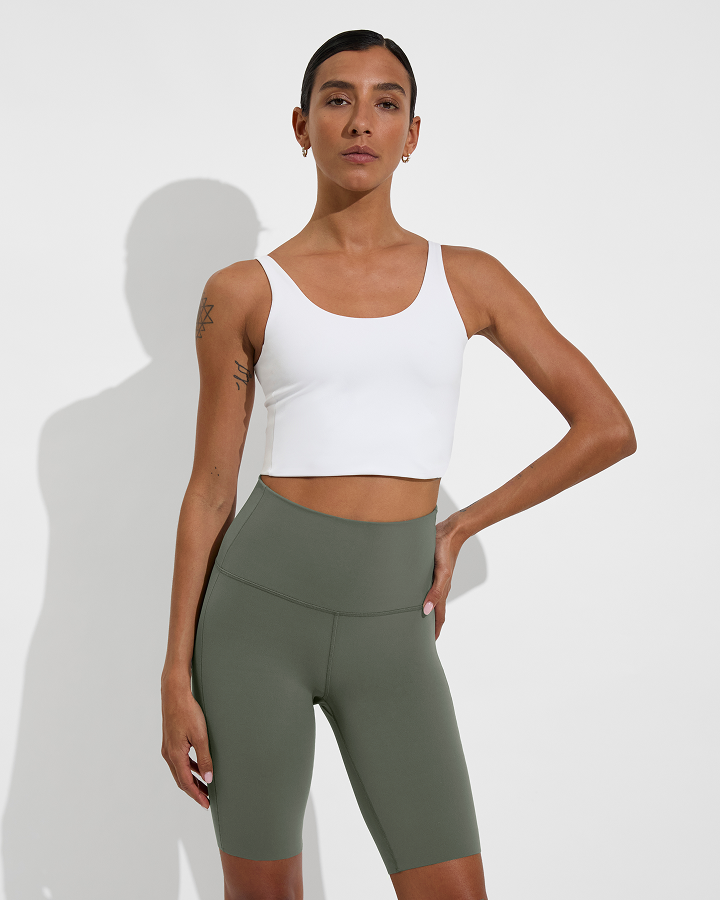 Woman in reset tank in Coconut paired with super moves short 9" in Agave