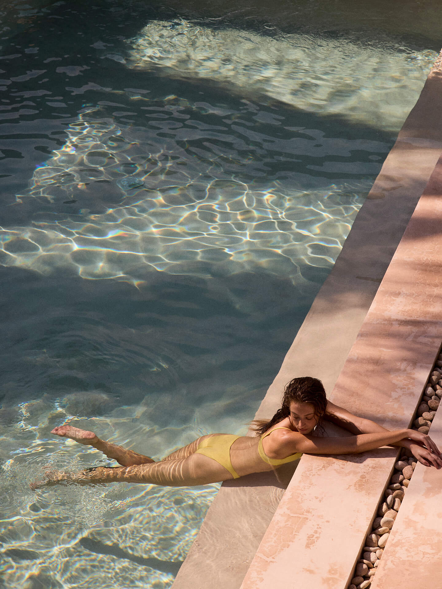 Woman in a pool wearing Sunday Top paired with Throwback Bottom in Melt