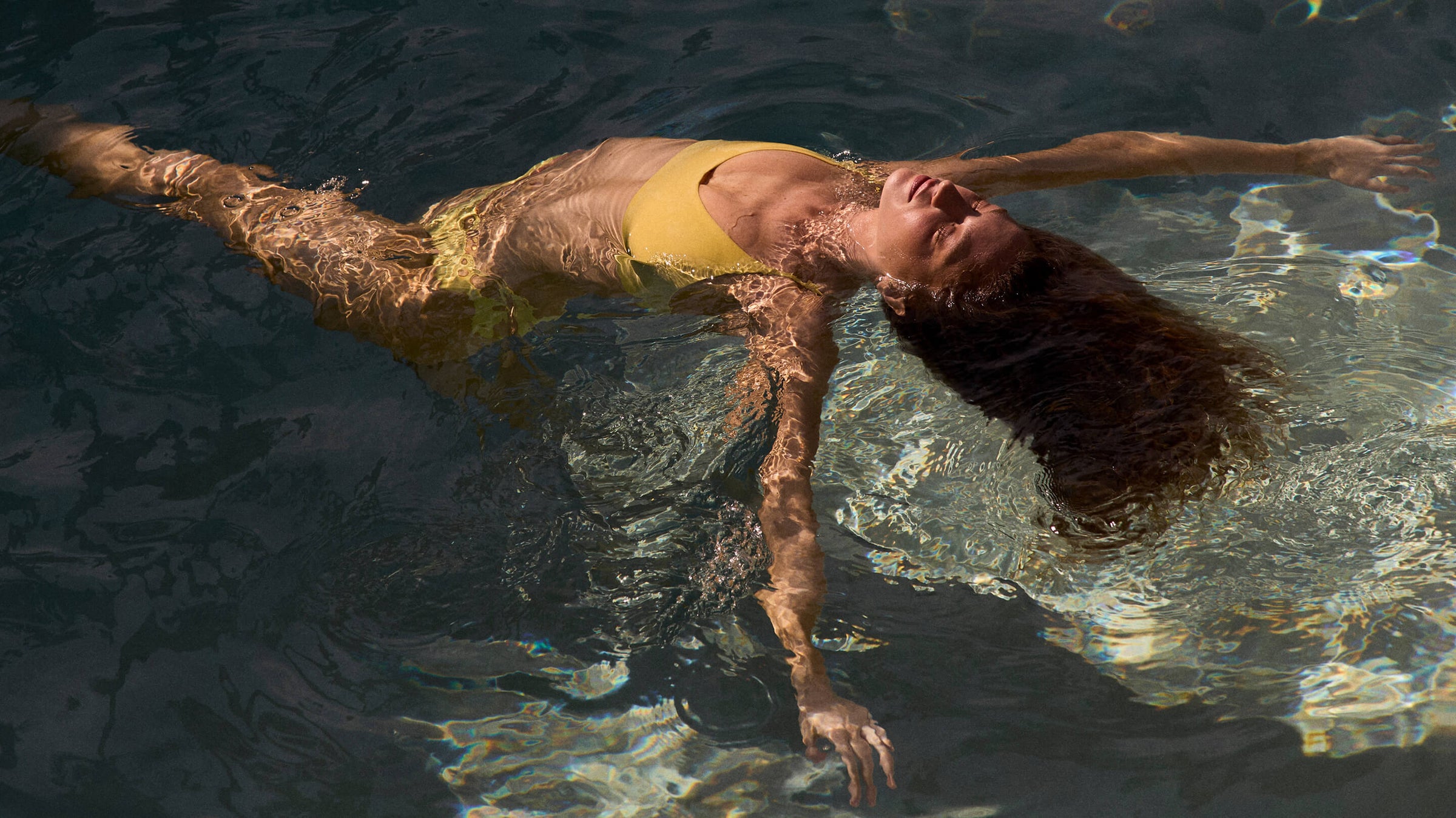 Woman in a pool wearing Sunday Top paired with Throwback Bottom in Melt