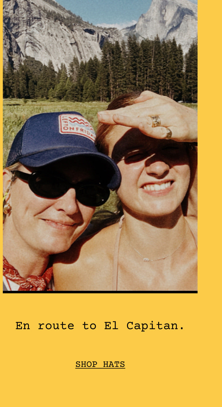 A yellow promotional graphic featuring a close-up photo of two women outdoors in front of mountains and trees, with text below reading 'En route to El Capitan.' and 'SHOP HATS'.
