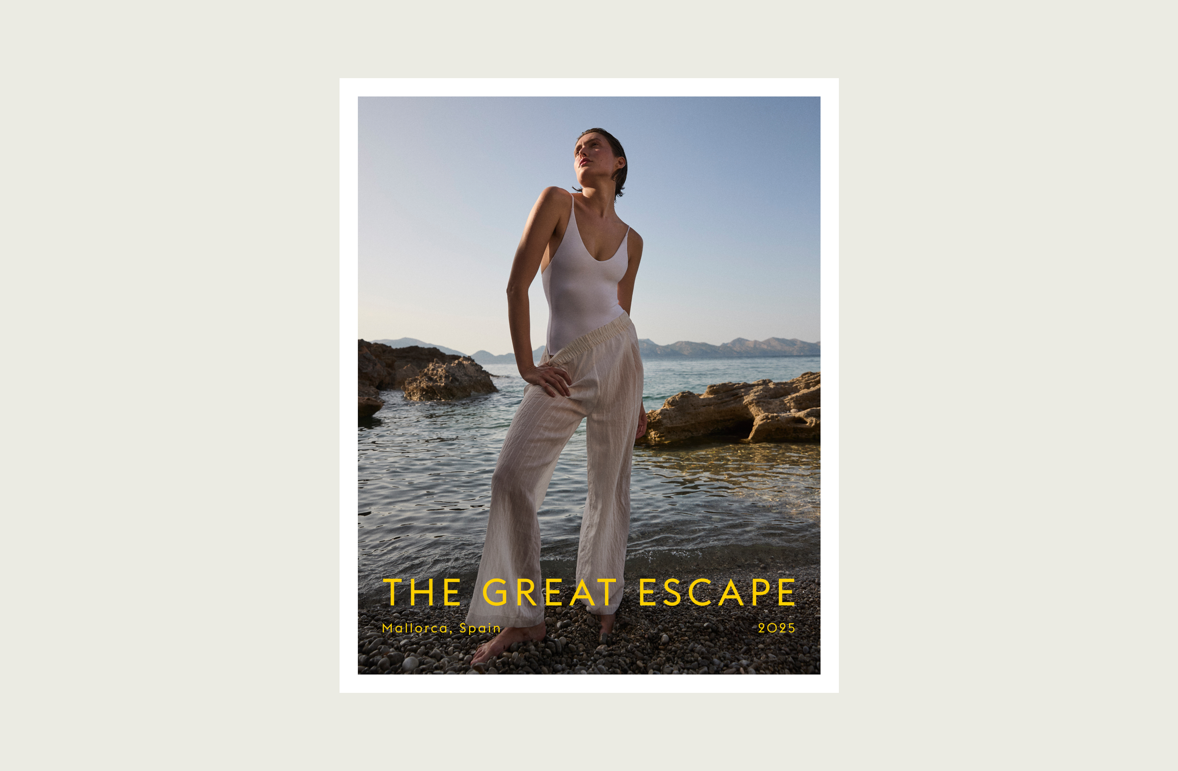 Woman in a white outfit standing by the water with 'The Great Escape' text.