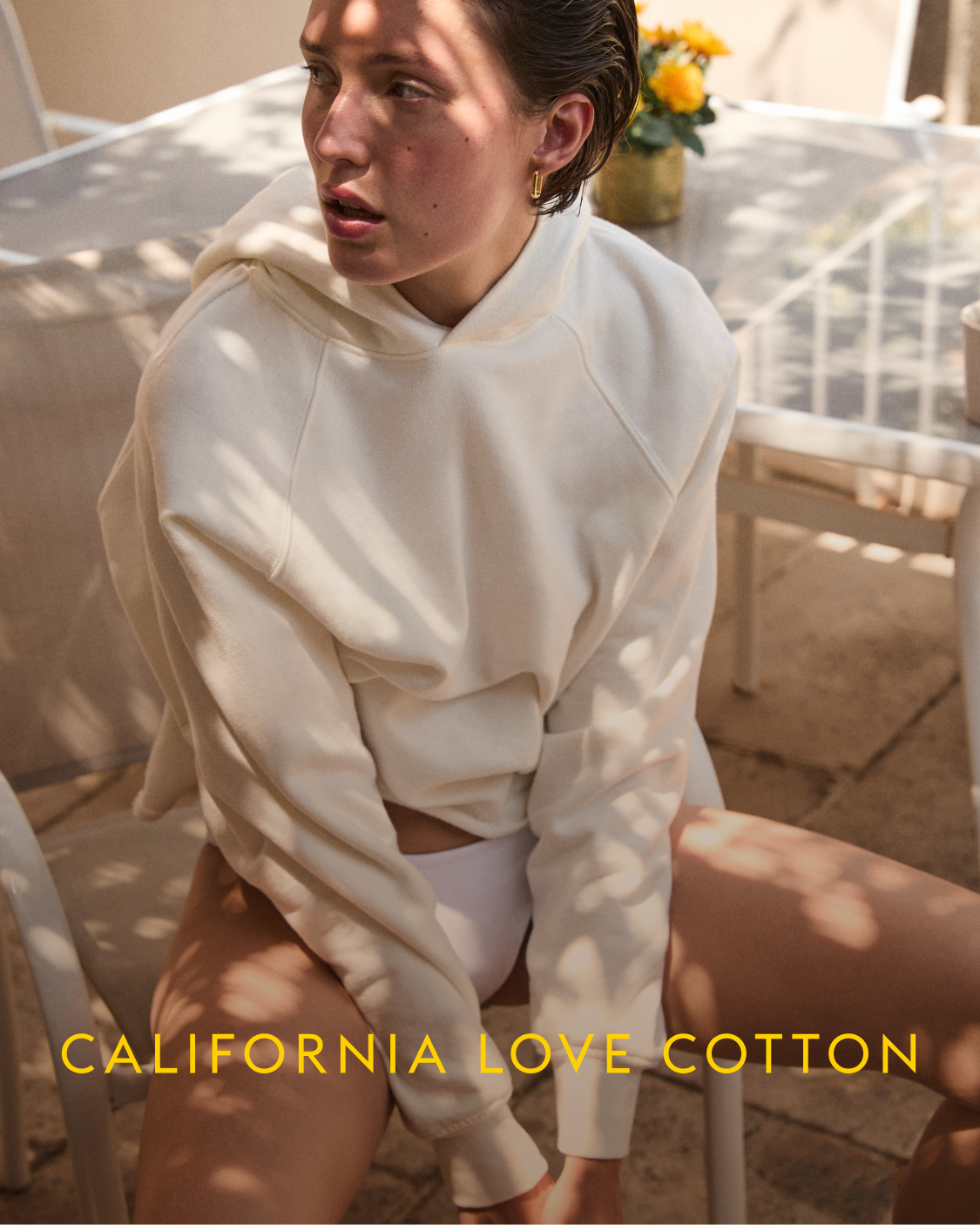 Person wearing a white outfit sitting outdoors with 'California Love Cotton' text.