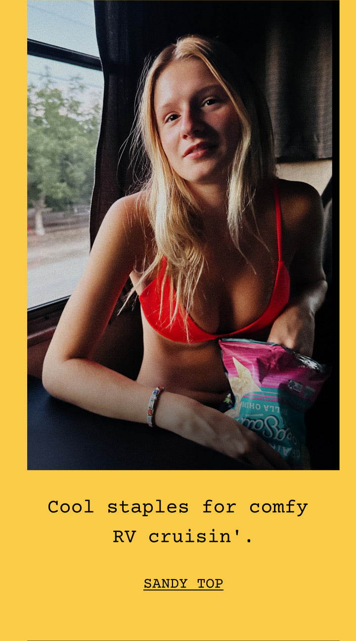 A woman in sandy top in rescue sits by a window in a dim interior, with a yellow border and the text 'Cool staples for comfy RV cruisin''. SANDY TOP' below.