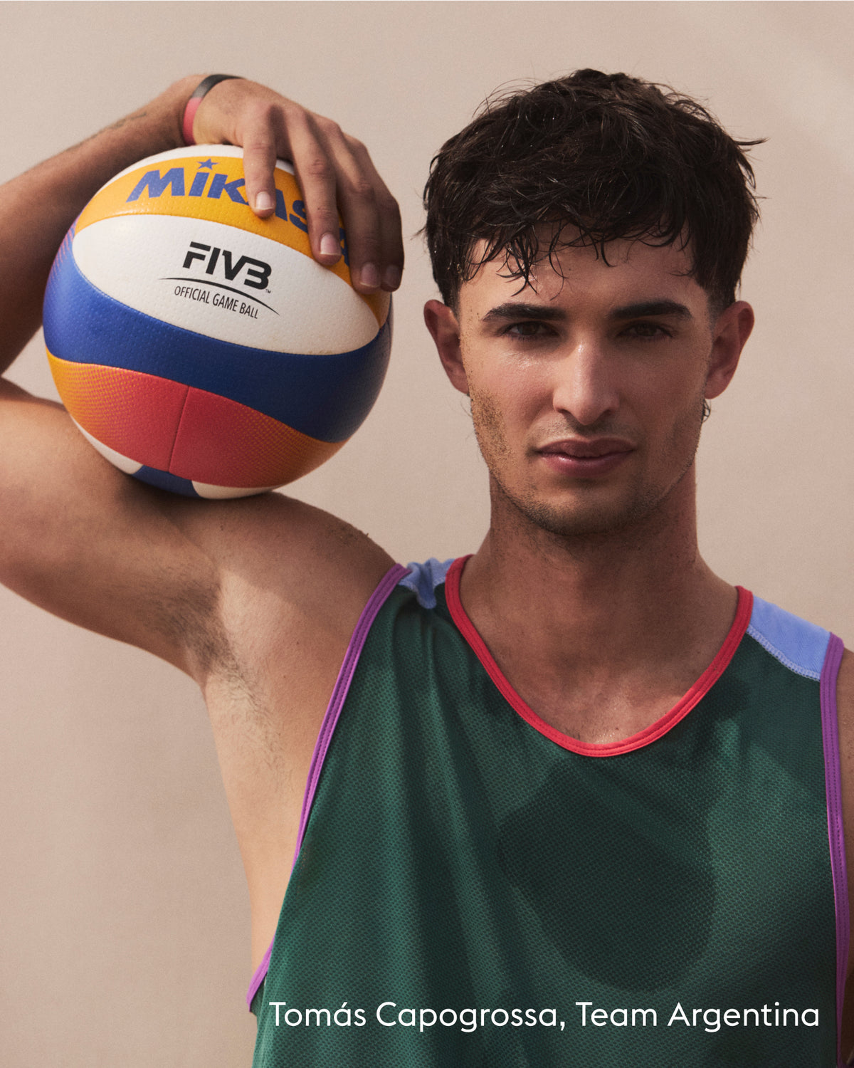 A man in a green athletic jersey holding a Mikasa FIVB official beach volleyball ball against a plain beige background. Text at the bottom reads 'Tomás Capogrossa, Team Argentina'.